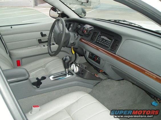 Gray leather interior of a 2003 Ford Crown Victoria, showing dashboard, steering wheel, center console, and seats