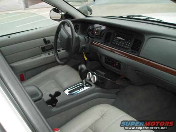 2003 Ford Crown Victoria interior showing dashboard, steering wheel, center console with automatic shifter, and grey leather seats