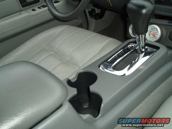 Gray leather interior with center console, gear shifter, and voltmeter gauge