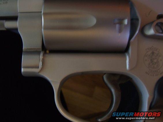 Close-up of a revolver cylinder and trigger guard. Smith & Wesson logo visible