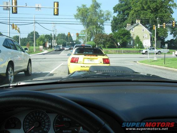 Yellow 2003 Ford Mustang convertible at intersection, seen from driver's perspective