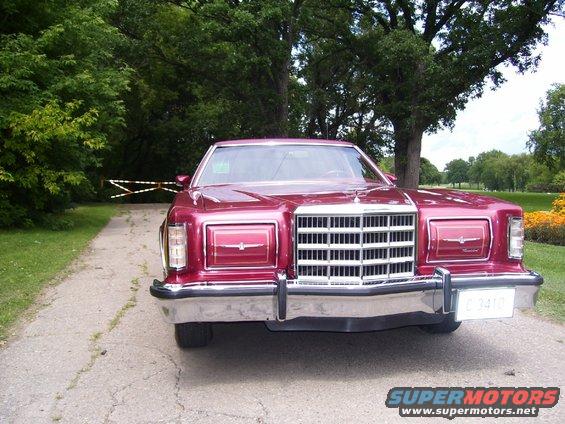 Front view of a red 1977 Ford Thunderbird parked on a gravel driveway