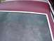 1979 Ford Thunderbird - Close-up view of the rear window and roofline of a vehicle, showing chrome trim and a burgundy-colored roof.