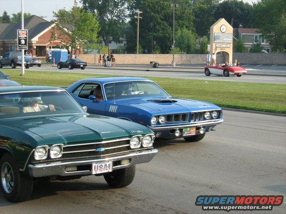 Blue 1970 Plymouth Barracuda with a hood scoop and chrome grille, seen from the front
