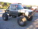 1984 Ford Bronco II - This heavily modified pickup truck features oversized tires and a roll cage, suggesting it's built for off-road use.