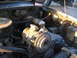 1984 Ford Bronco II - Close-up view of an engine bay, focusing on the air conditioning compressor and related components.