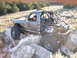 1984 Ford Bronco II - A heavily modified pickup truck navigates a rocky trail, its off-road capabilities.