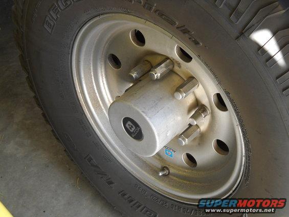 Close-up of a silver wheel hub with lug nuts and a BFGoodrich tire. Alcoa logo visible on hubcap