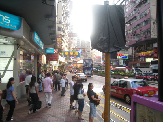 Red taxi cab driving on a busy street in a city