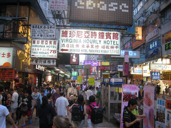 Crowded street in a city with lots of neon signs and shops