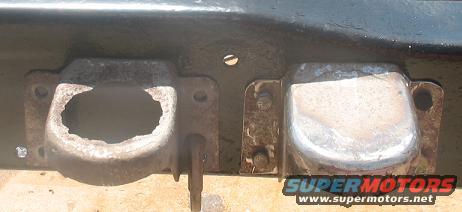 two rusty metal frame mounts on a vehicle, one is broken