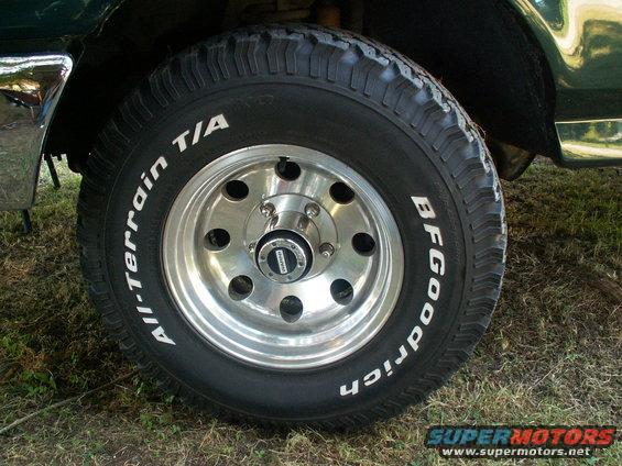 Close-up of a BFGoodrich All-Terrain T/A tire on a shiny alloy wheel. Chrome fender trim visible