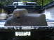 1979 Ford Bronco - A weathered oil pan is positioned in the back of a pickup truck, obscuring the license plate.