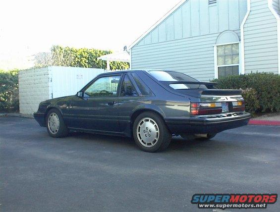 Dark blue 1987 Ford Mustang coupe with a rear spoiler, viewed from the rear
