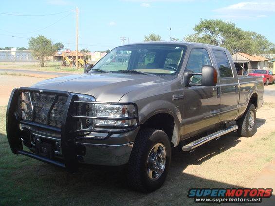 Gray 2005 Ford F-250 truck with a black brush guard and chrome side steps, parked outdoors