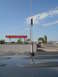 2005 Ford F-250 - A mobile ham radio antenna is mounted on the roof of a dark vehicle, with a gas station canopy in the background.