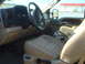 2005 Ford F-250 - The interior of a 2005 Ford F-250 pickup truck features tan leather seats and wood trim accents.
