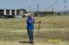 2005 Ford F-250 - A man flies a kite in a grassy field with a hotel and parked cars visible.