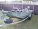 1993 Ford C-150 (Centurion Conversions) - A jon boat with registration TX 9068 CU is parked on a trailer in a grassy yard.