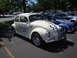 1964 Ford Fairlane - A classic Volkswagen Beetle, often called a "Bug", is displayed at a car show with other vehicles.