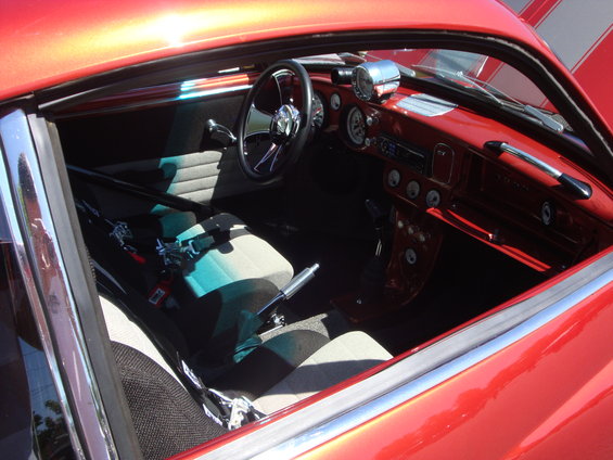Red car interior with racing seats, roll cage, and custom gauges