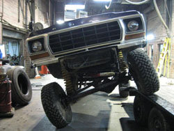 1978 Ford Bronco front end lifted on a hoist, showing suspension and grille