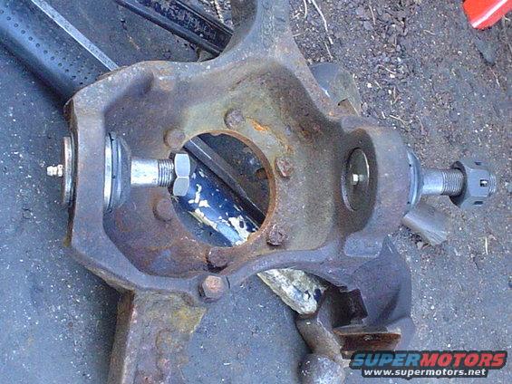 Close-up of a rusty suspension part with bolts and nuts