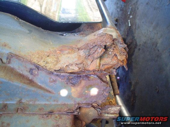 Heavily rusted metal frame section with visible corrosion and damage