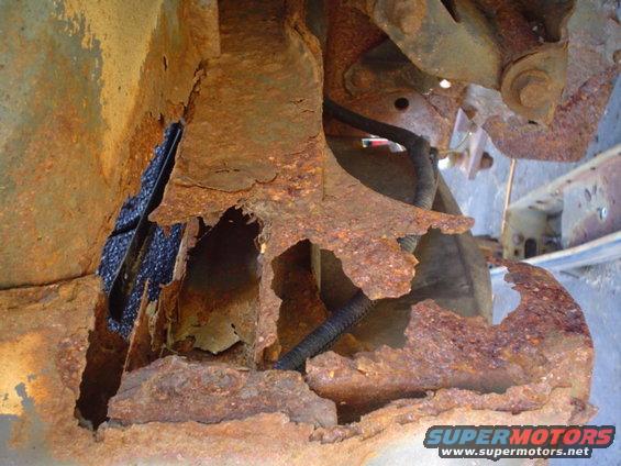 Heavily rusted vehicle frame with exposed wiring