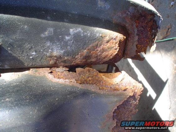 Heavily rusted metal, possibly a frame or body panel, showing significant corrosion and deterioration