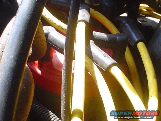 Yellow spark plug wires and black boots in engine bay