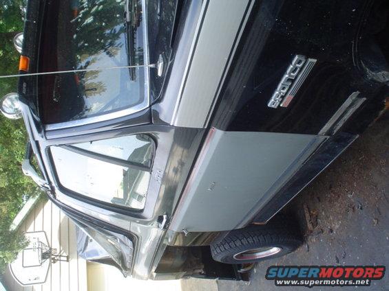Side view of a black 1988 Ford Bronco with silver trim and a 'Bronco' badge on the fender
