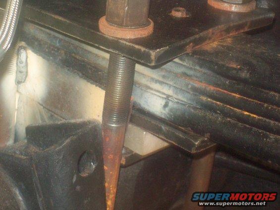 close-up of a rusty bolt and metal plate on a vehicle's suspension