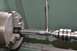 1996 Ford Bronco - A tap is being centered in a lathe chuck, with a wrench holding the tap and a tailstock center supporting it.