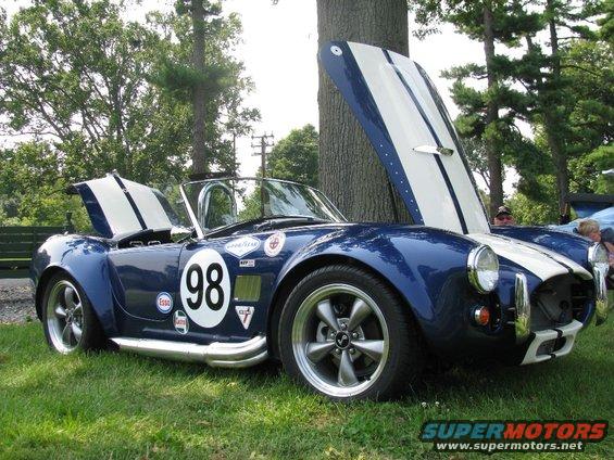 Blue and white race car with number 98 on door, hoods open