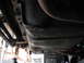 1991 Ford Bronco - Underside view of a vehicle's fuel tank and frame rails, showing some wear and tear.