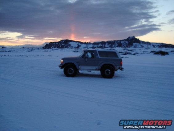 1992 Ford Bronco parked in a snowy landscape with mountains in the background