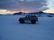 1992 Ford Bronco - A 1992 Ford Bronco sits in a vast, snow-covered field under a dramatic sky.