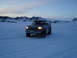 1992 Ford Bronco - A 1992 Ford Bronco sits in a vast, snow-covered terrain under a twilight sky.