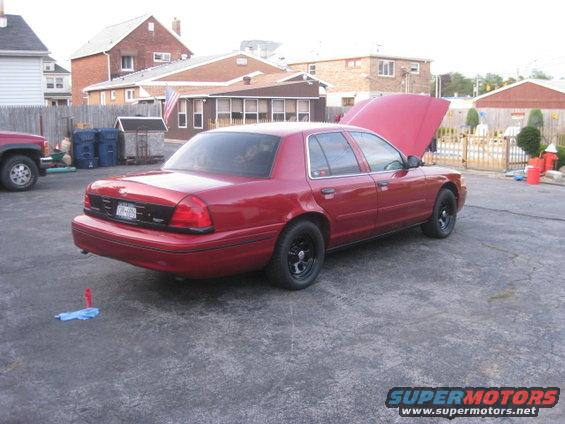 Red 2000 Ford Crown Victoria with hood open, parked in a driveway