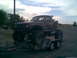 1984 Ford Bronco II - Pickup truck with significant modifications, including oversized tires, loaded onto a trailer.
