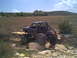 1984 Ford Bronco II - This heavily modified truck navigates a rocky terrain, its custom roll cage and oversized tires evident.