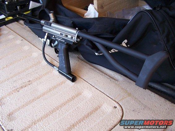 Silver and black paintball gun with a black stock and bag
