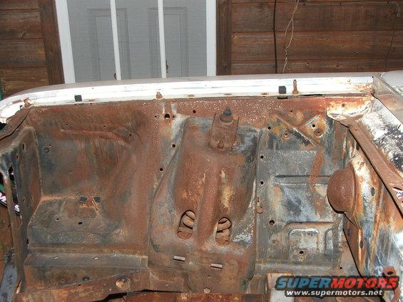 1963 Ford Fairlane engine bay firewall, heavily rusted, white exterior trim visible