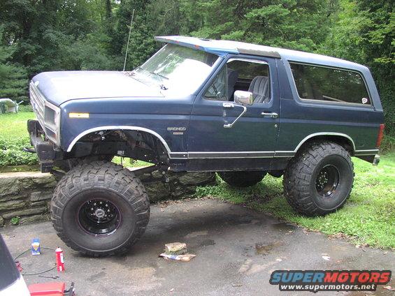 Blue lifted Ford Bronco with large off-road tires, viewed from the front three-quarter angle