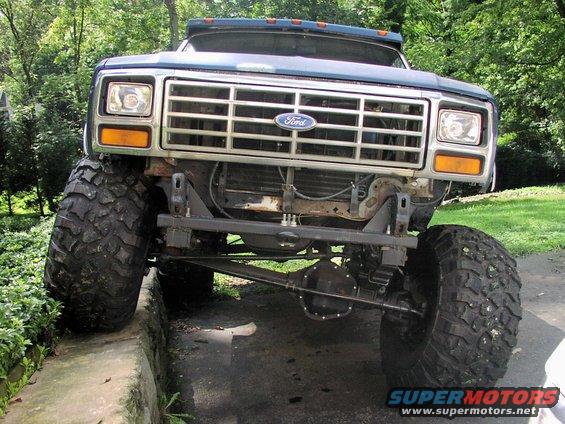 Front view of a lifted blue 1986 Ford Bronco with large off-road tires