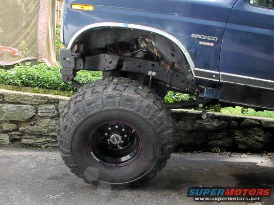 Blue 1986 Ford Bronco with large off-road tires, front fender removed