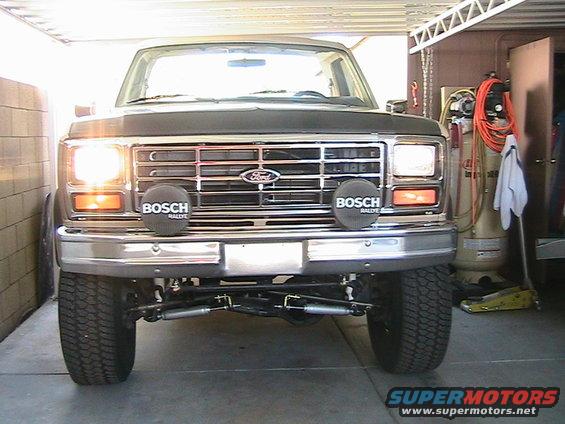 Dark gray Ford Bronco front view with chrome grille, Bosch fog lights, and lifted suspension