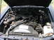 1985 Ford LTD - The engine compartment of a car is shown with the hood open, revealing various engine components and wiring.