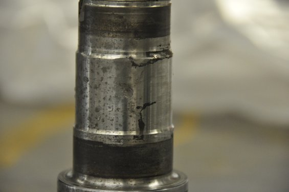Close-up of a worn metal spindle with some black residue and scratches